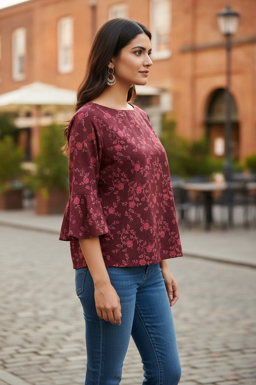 Naanu deep wine burgundy georgette top with pink floral vine print, boat neck, and bell sleeves.