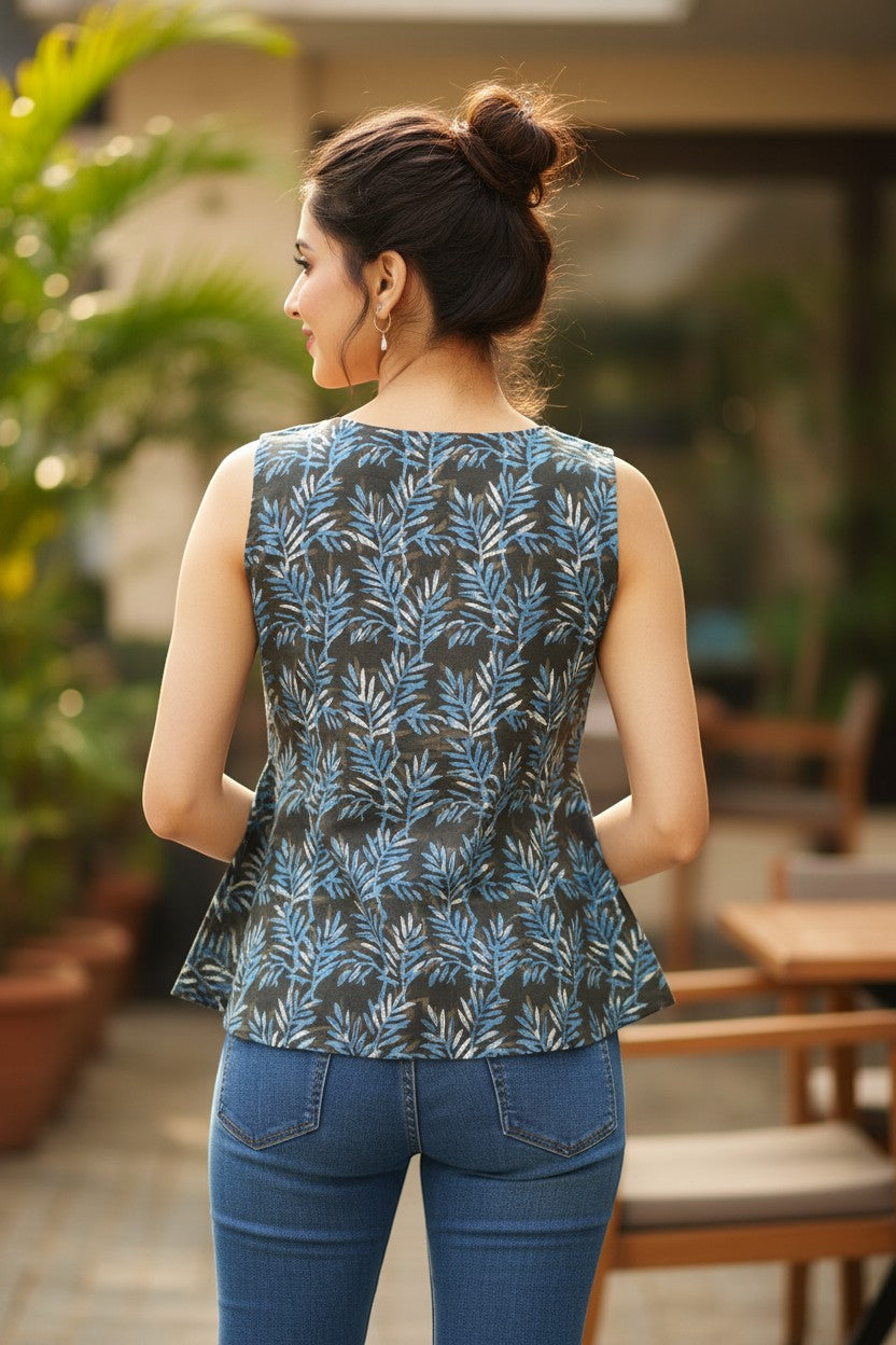 Naanu dark olive grey sleeveless A-line top with blue and white tropical leaf print, round scoop neck, flared silhouette.