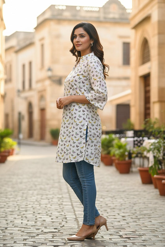 Naanu white short cotton kurti with all-over butterfly print, V-notch neckline, and 3/4 straight sleeves.