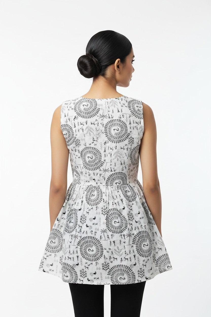 Naanu white cotton short kurta with black Warli tribal print, sleeveless, round neck, flared peplum silhouette.