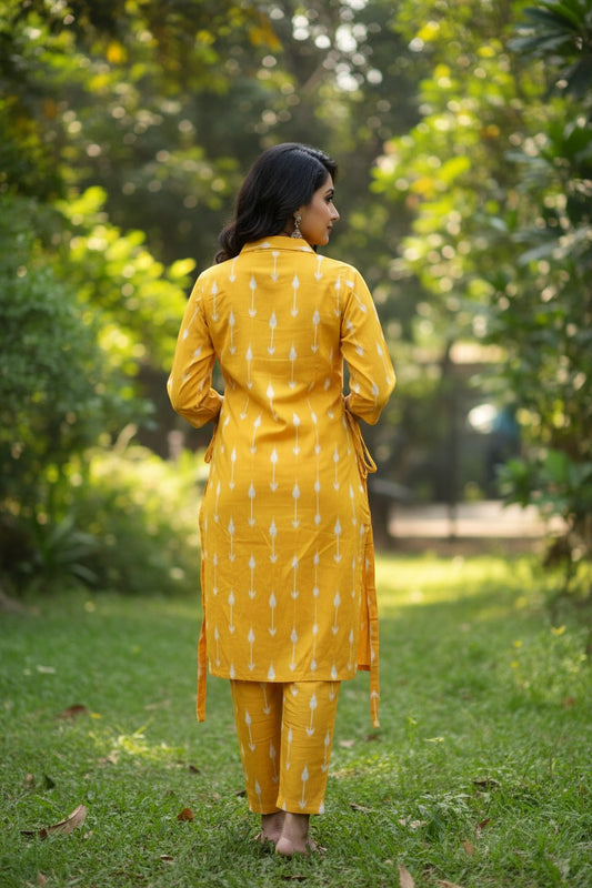 Naanu yellow ikat arrow print straight kurta with 3/4 sleeves and matching pants. Features a shirt collar and side tie-up detail.