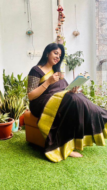 Black and green Assam silk saree - model seated in garden