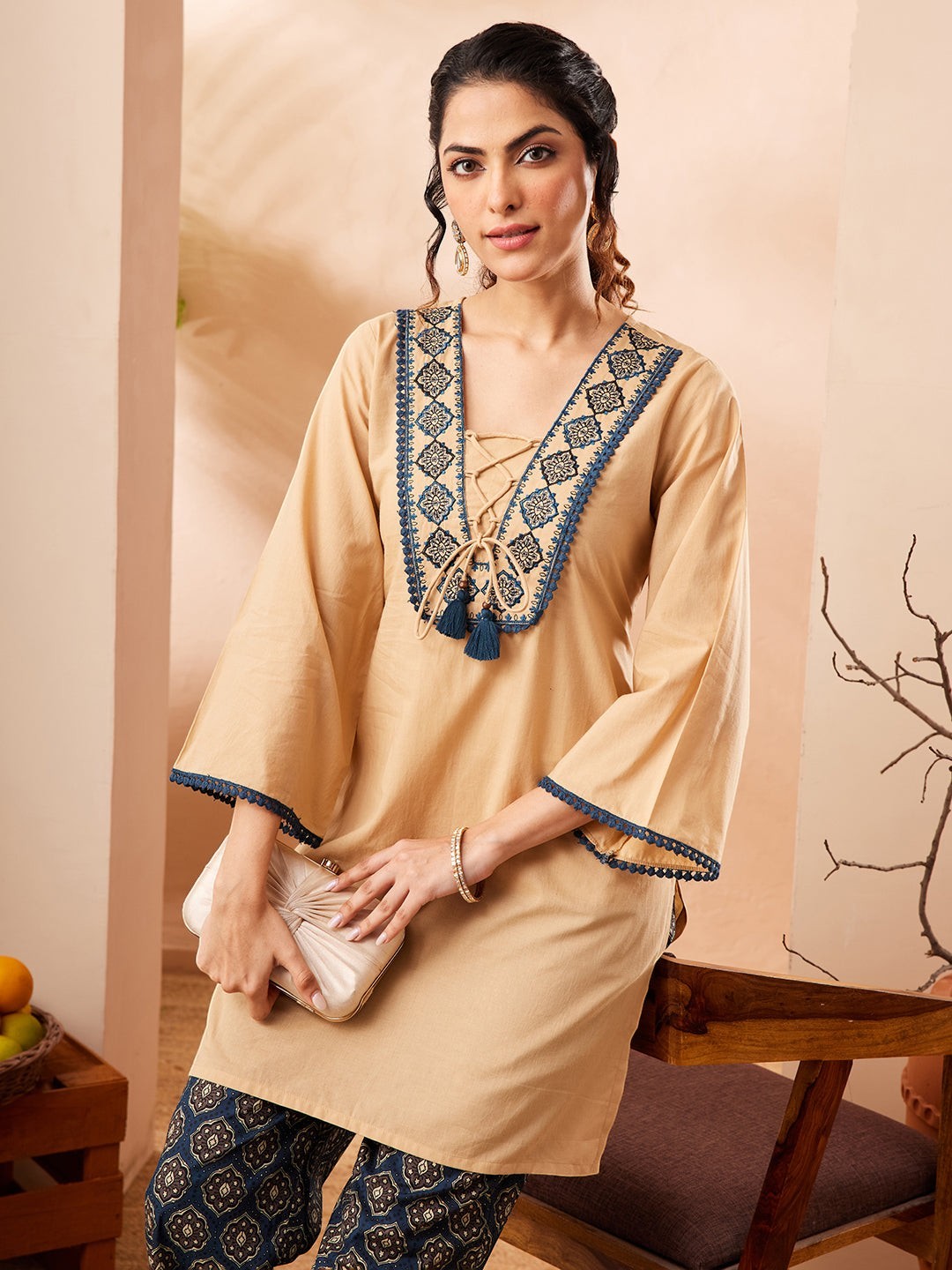 Naanu beige cotton co-ord set with embroidered V-neck, lace-up tie, and bell sleeves paired with navy Ajrakh print palazzo pants.