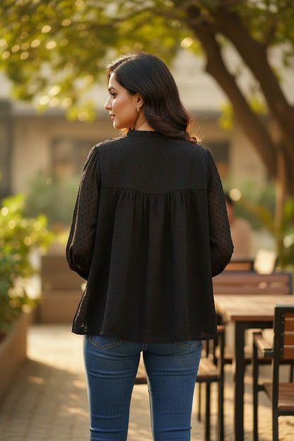 Naanu black georgette dobby dot smock top with mandarin collar and button placket, featuring a voluminous flowy silhouette.