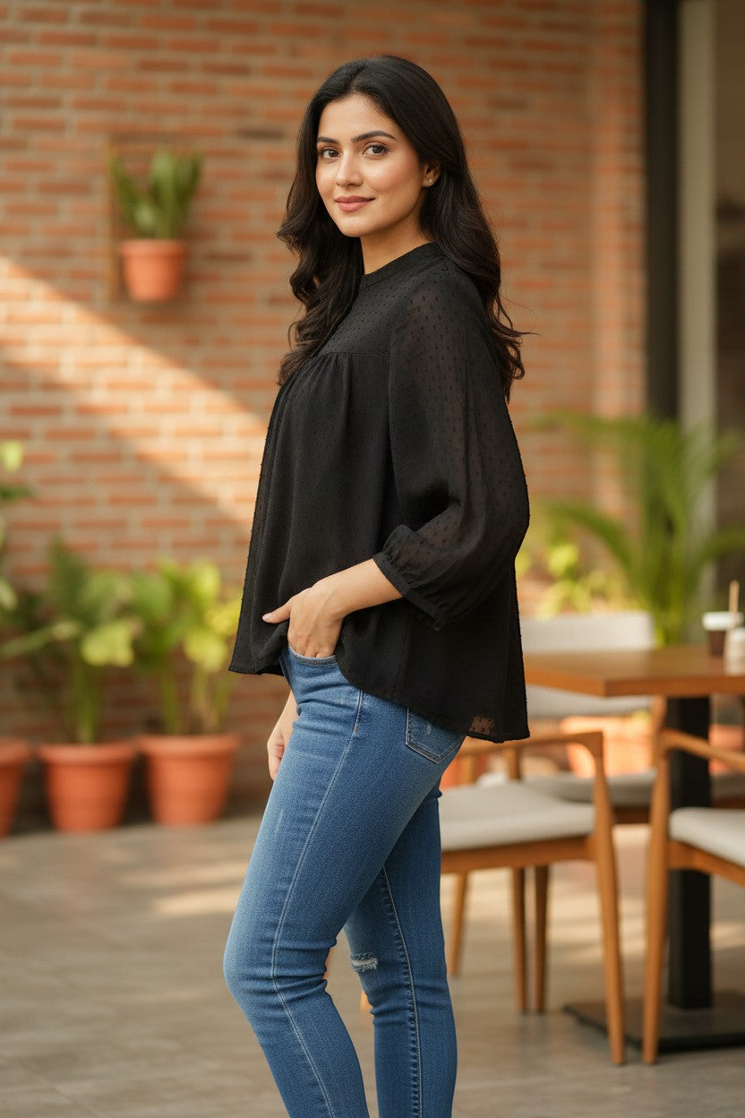 Naanu black georgette dobby dot smock top with mandarin collar and button placket, featuring a voluminous flowy silhouette.