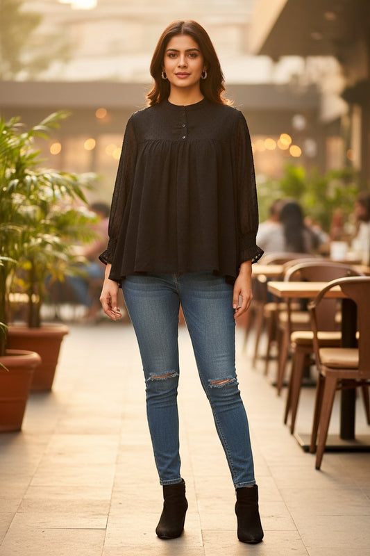 Naanu black georgette dobby dot smock top with mandarin collar and button placket, full sleeves, voluminous fit.