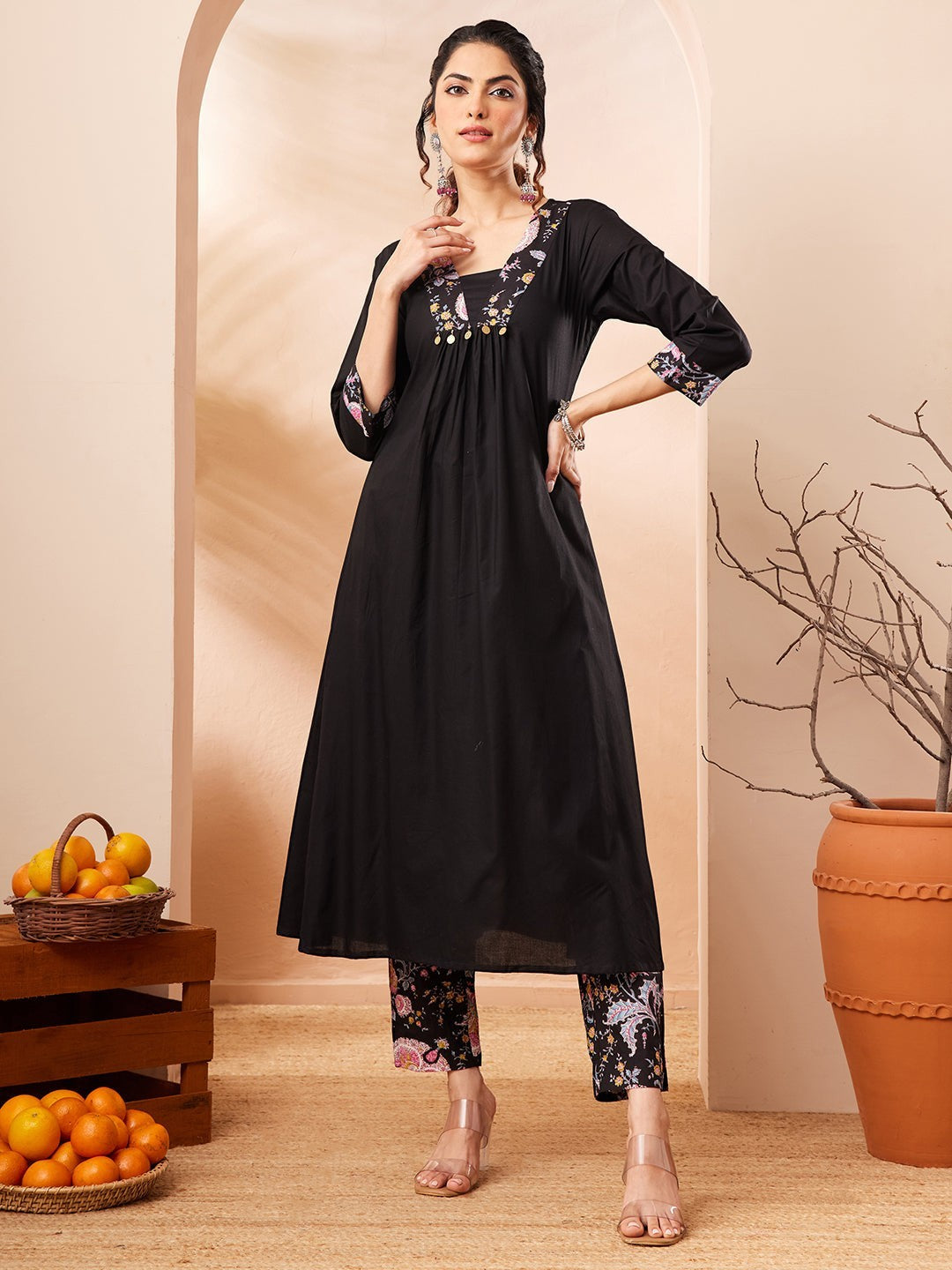 Naanu black A-line kurta with embroidered square neckline and floral print slim pants. 3/4 sleeves with embroidered cuffs.