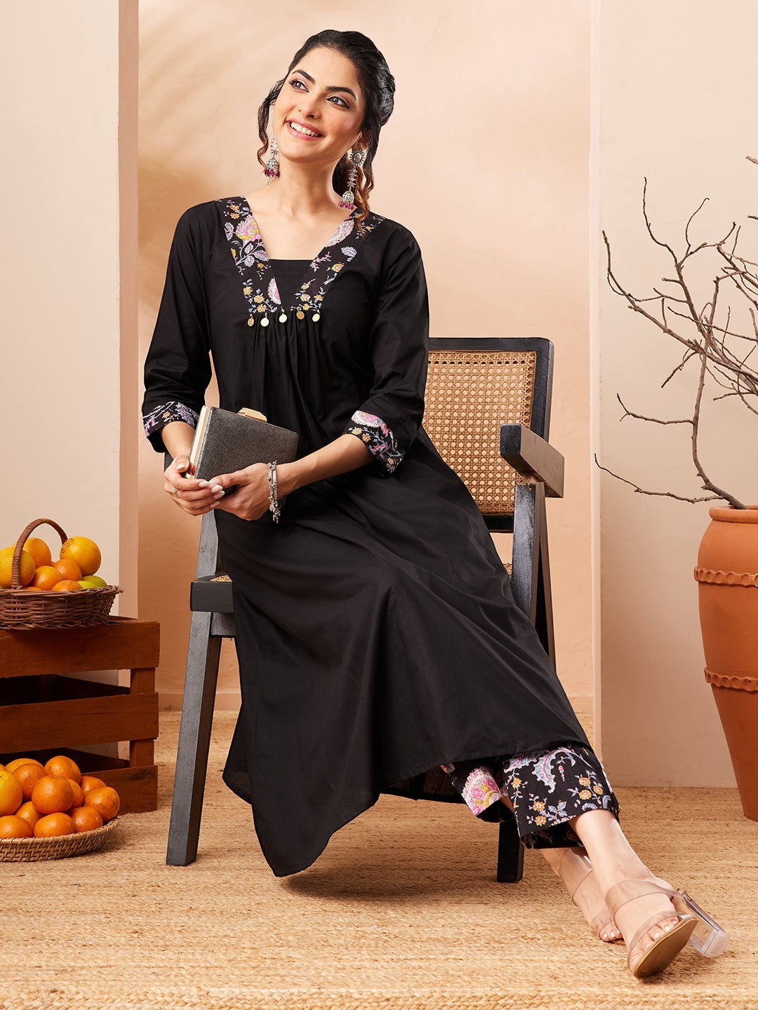 Naanu black A-line kurta with embroidered square neckline and floral print slim pants. 3/4 sleeves with cuff border.