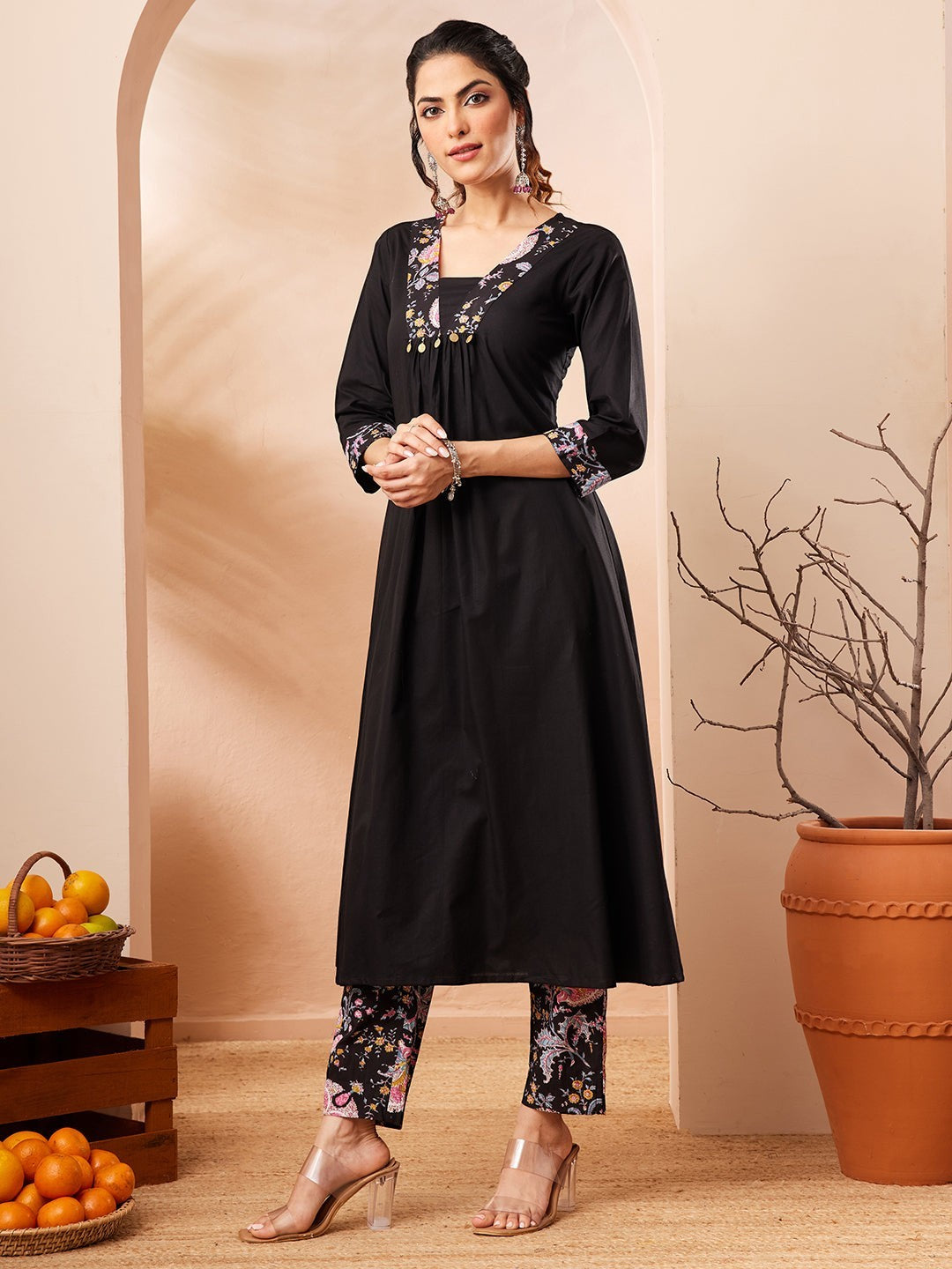 Naanu black A-line kurta with embroidered square neckline and floral print slim pants. 3/4 sleeves with embroidered cuffs.