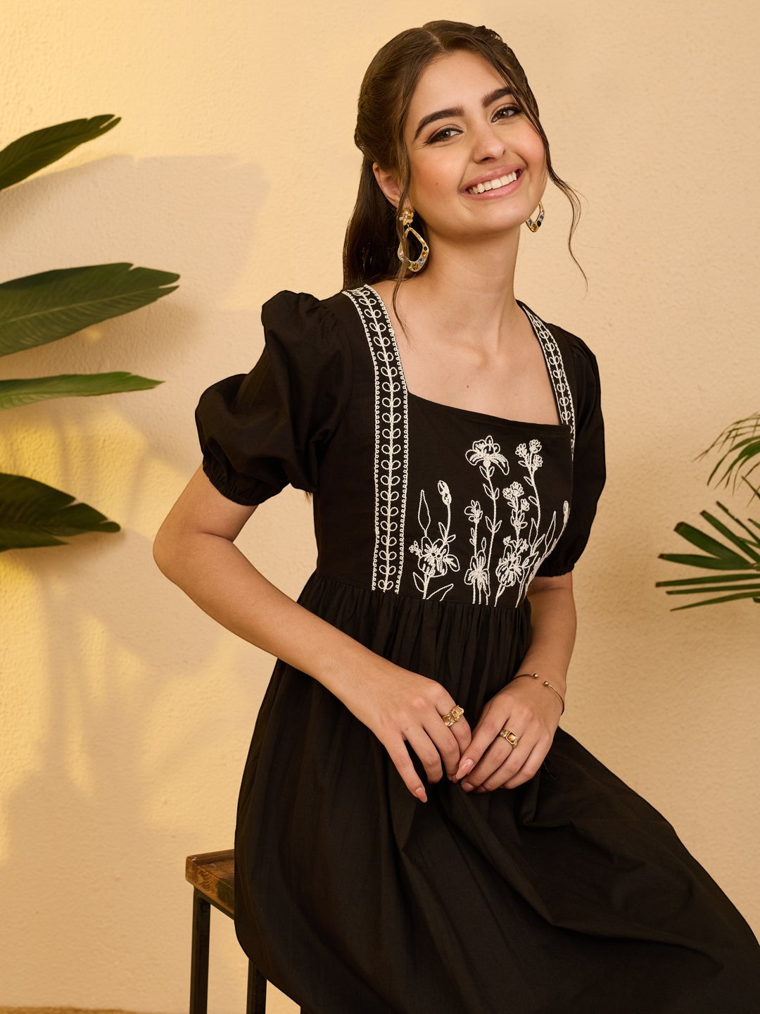 Naanu black cotton midi dress with white floral embroidery on bodice, square neckline, and puff sleeves.