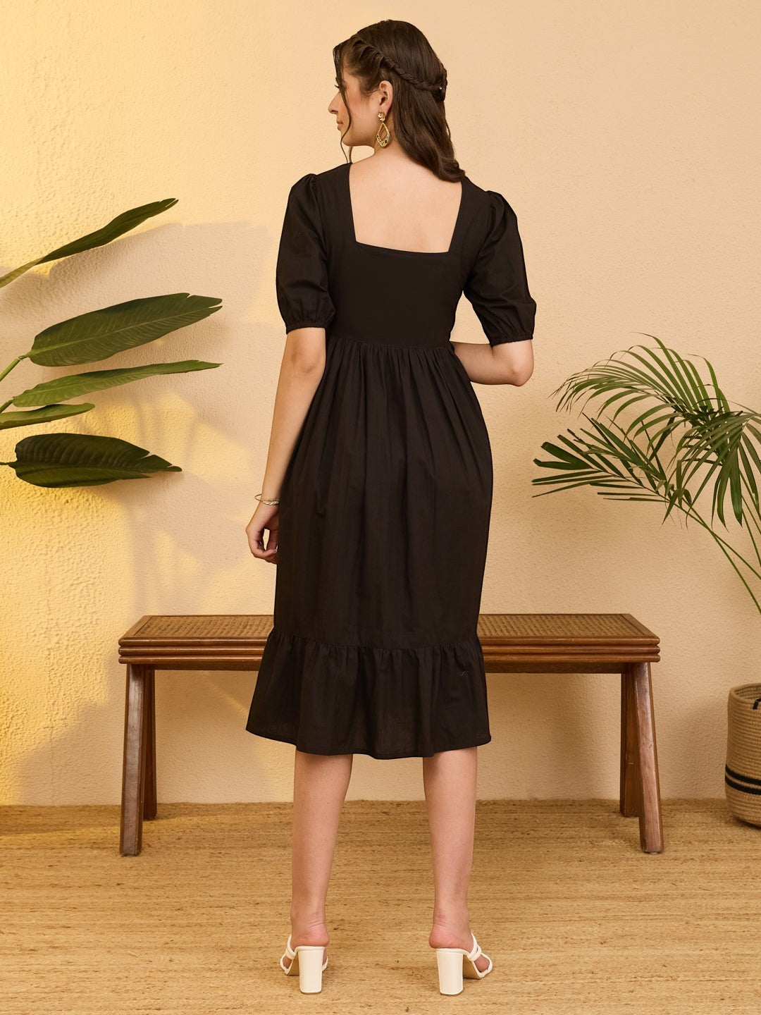 Naanu black cotton midi dress with puff sleeves, square neckline, and tiered ruffle hem. Features white floral embroidery.