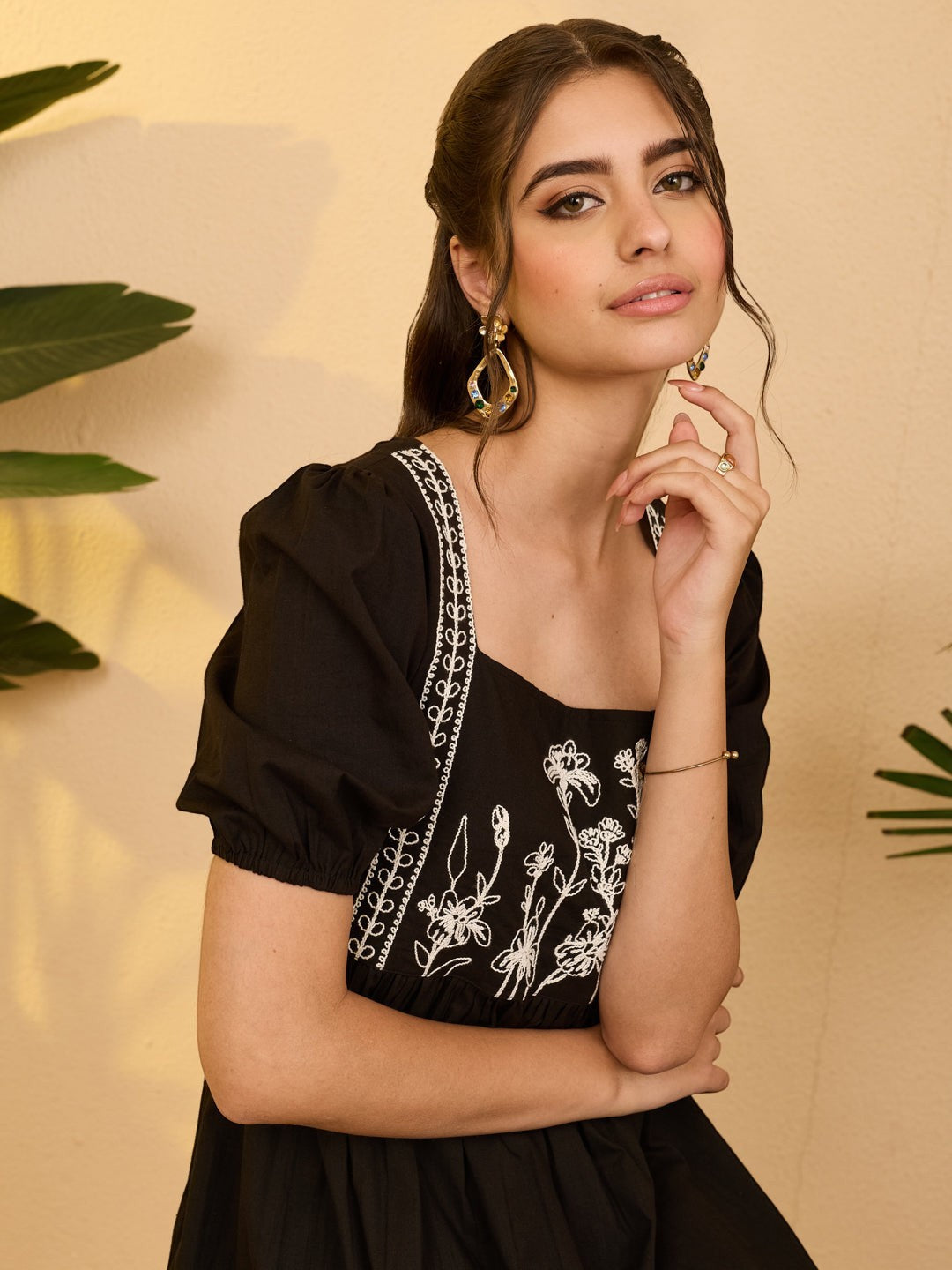 Naanu black cotton midi dress with white floral embroidery on bodice and puff sleeves, square neckline.