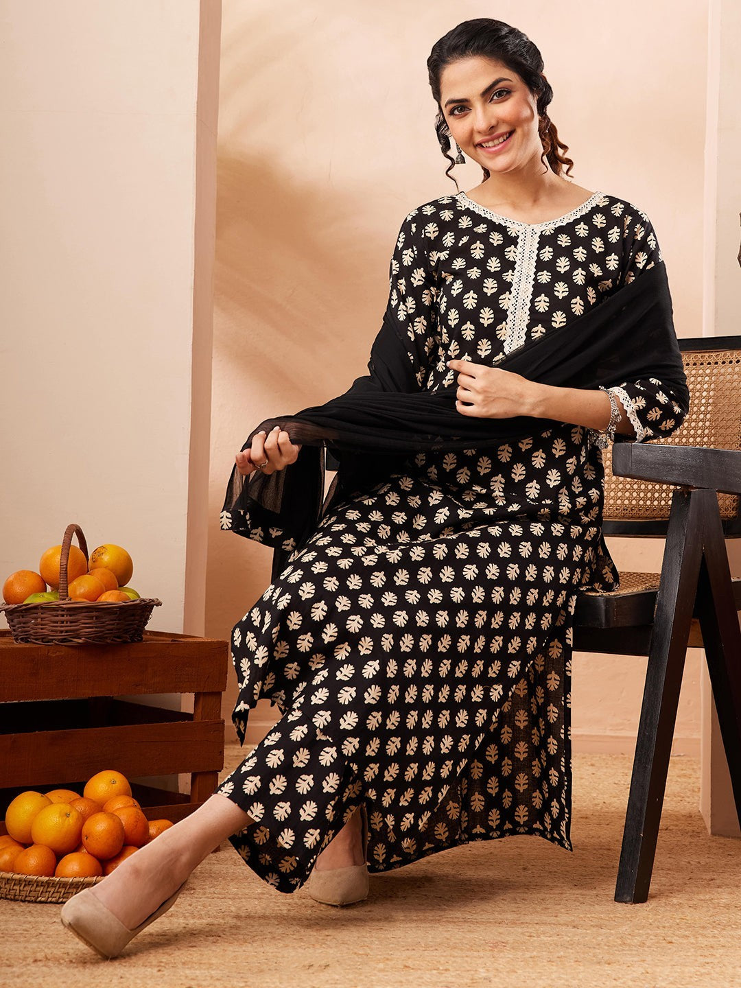 Naanu black rayon kurta set with gold leaf print, white lace trim, straight pants, and chiffon dupatta.