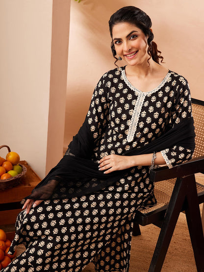Naanu black rayon kurta set with gold leaf print, white lace trim, straight pants and black chiffon dupatta.