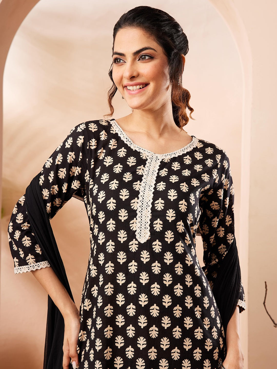 Naanu black rayon kurta with ivory and gold leaf print, white lace trim, and 3/4 sleeves. Paired with matching pants and dupatta.