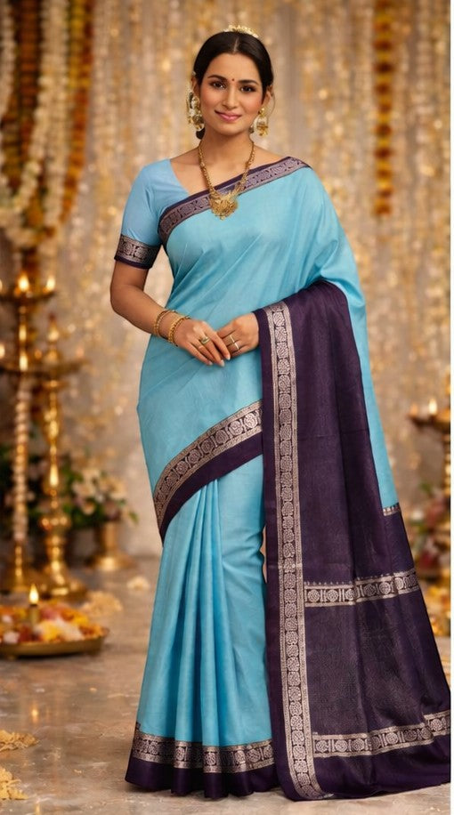 Naanu light blue Chanderi silk saree with a deep purple contrast border featuring intricate silver motifs. Model wears gold jewelry.