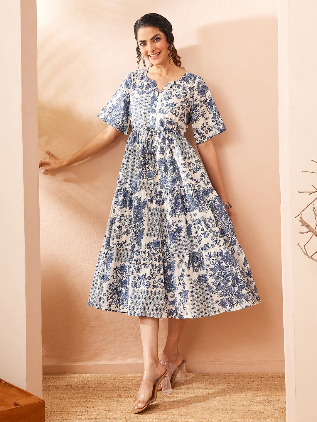 Naanu blue and white floral patchwork tiered midi dress with flutter sleeves and notched V-neckline.