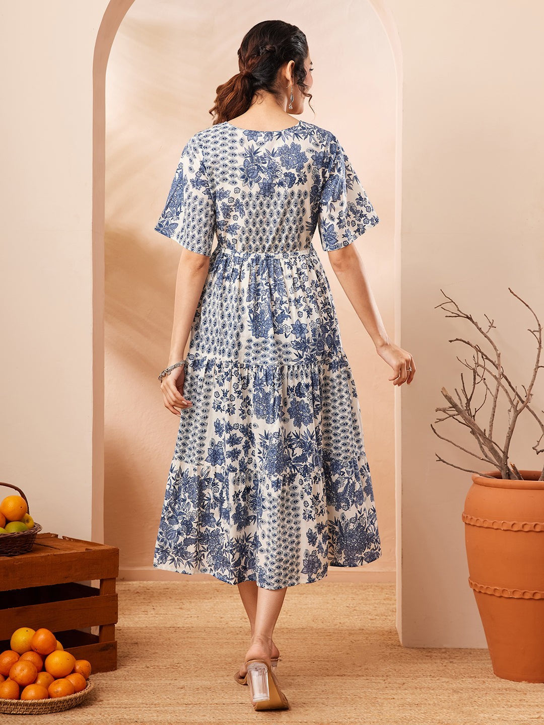 Naanu blue and white floral patchwork tiered midi dress with flutter sleeves and notched V-neckline.