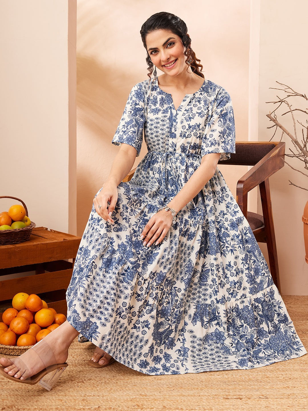 Naanu blue and white floral patchwork tiered midi dress with flutter sleeves and notched V-neckline.