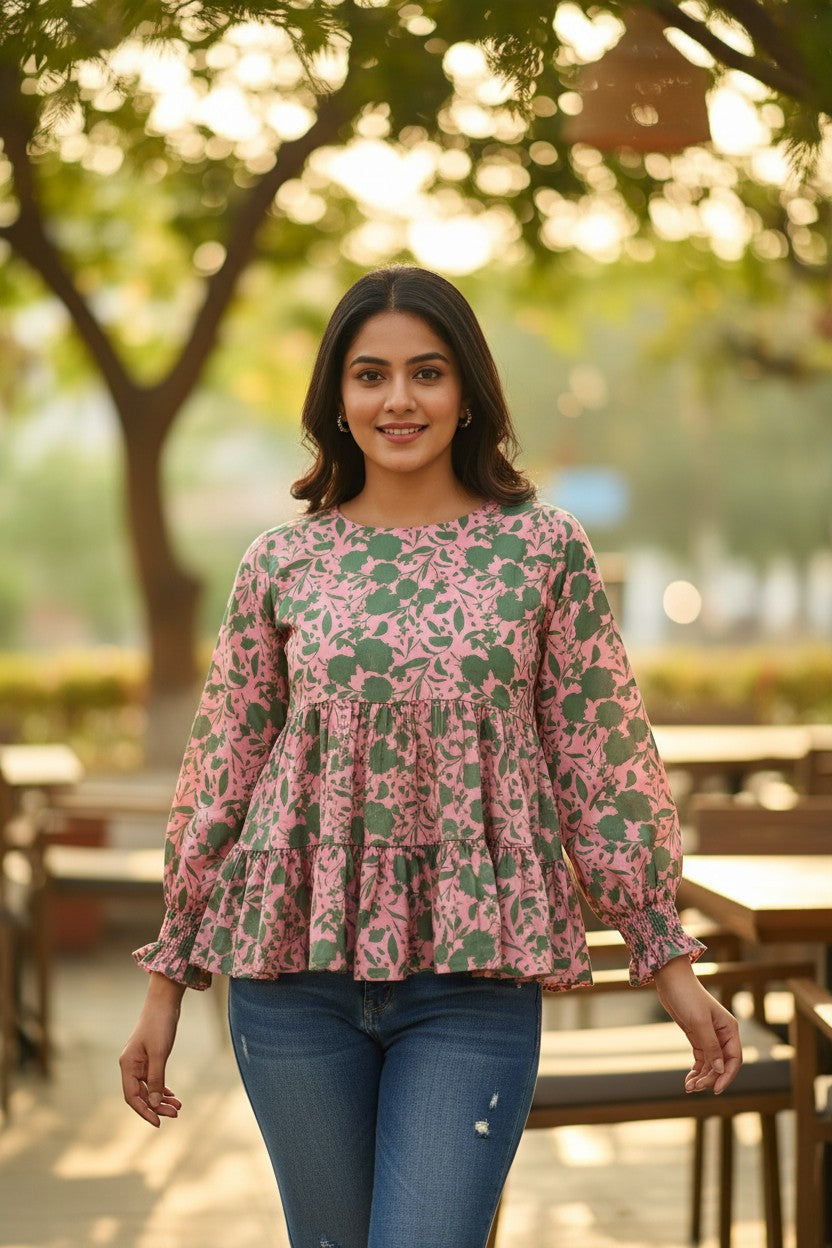 Naanu blush pink satin peplum top with green botanical print, tiered ruffle hem, and full sleeves.