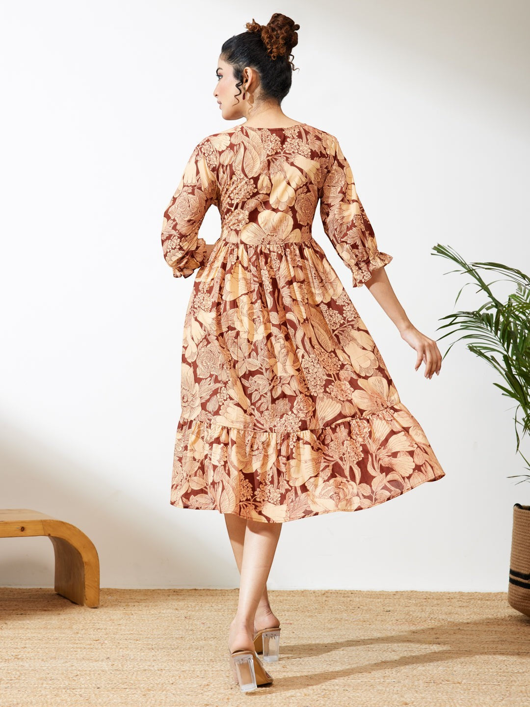 Naanu brown floral midi dress with V-neck, tiered skirt, and puff sleeves. Boho chic ethnic fusion wear.
