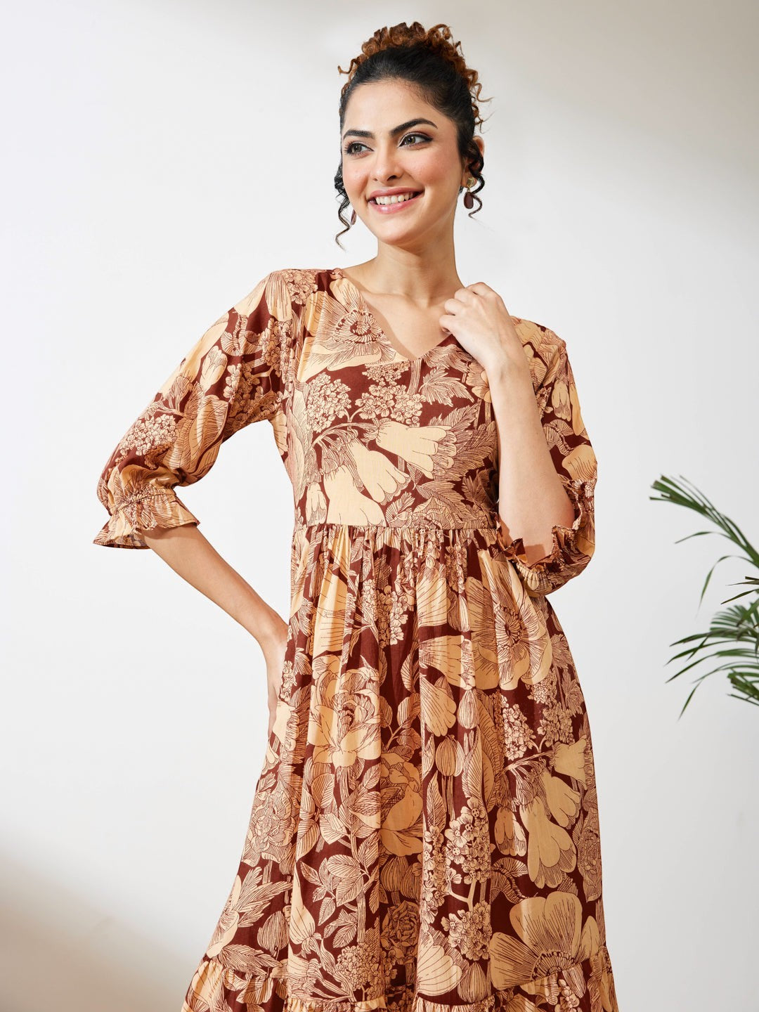 Naanu brown floral midi dress with V-neck, puff sleeves, and tiered skirt. Boho chic ethnic fusion wear.