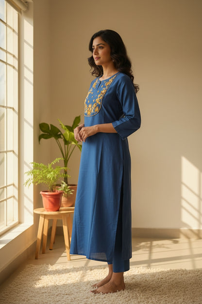 Naanu cerulean blue silk-like kurta with golden marigold floral embroidery on U-neckline yoke, short sleeves, and side slits.