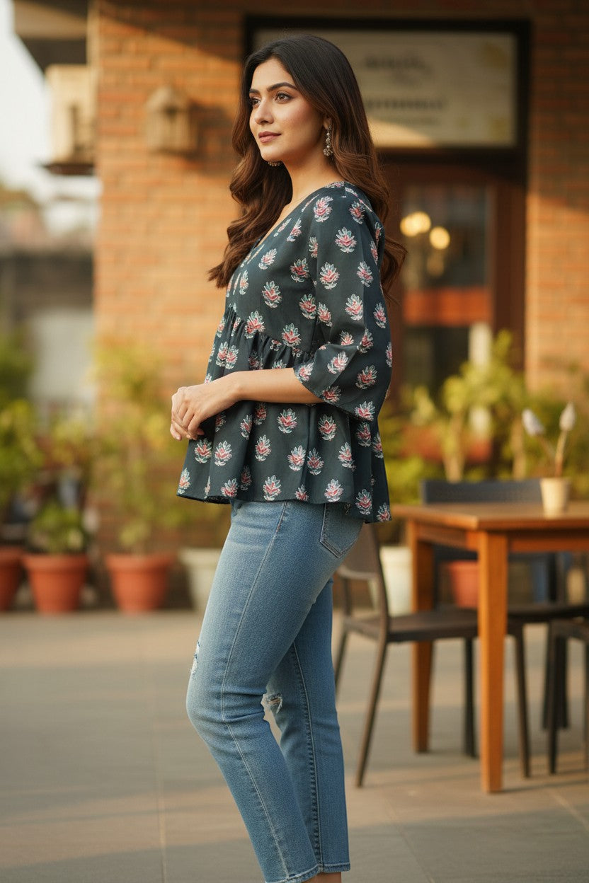 Naanu dark charcoal teal peplum top with pink lotus block print and 3/4 bell sleeves, paired with blue jeans.