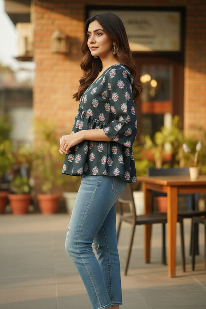 Naanu dark charcoal teal peplum top with pink lotus block print and 3/4 bell sleeves, paired with blue jeans.
