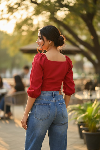 Naanu cherry red polyester short top with square neck, puff 3/4 sleeves, and button-down front, worn by a woman with her hair in a bun.