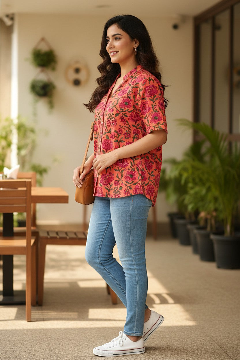 Naanu coral orange pink Sanganeri pomegranate floral block print cotton short shirt with V-notch neckline and pearl buttons.