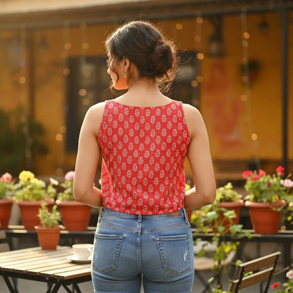 Naanu coral red sleeveless cotton top with white floral buta print, scoop neck, and button placket.