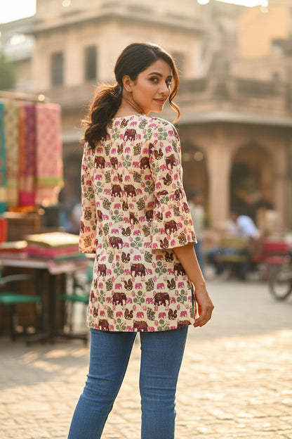 Naanu cream cotton kurti with elephant and peacock print, featuring 3/4 bell sleeves and a V-notch neckline.