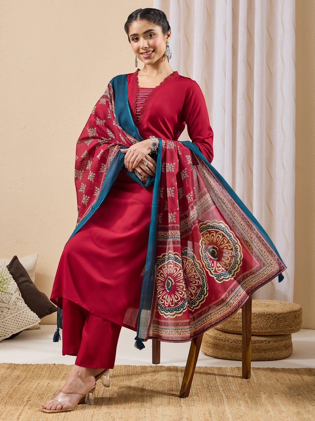 Naanu crimson red 3-piece ethnic set with lace trim straight kurta, slim pants, and printed dupatta with mandala motifs.