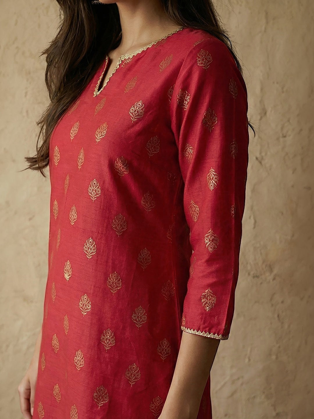 Naanu crimson silk blend straight kurta with gold foil butti print, notched V-neck, and gold lace trim.