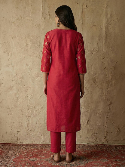 Naanu crimson silk blend straight kurta set with gold foil butti print, gold lace trim on notched V-neck and 3/4 sleeves, paired with straight pants.