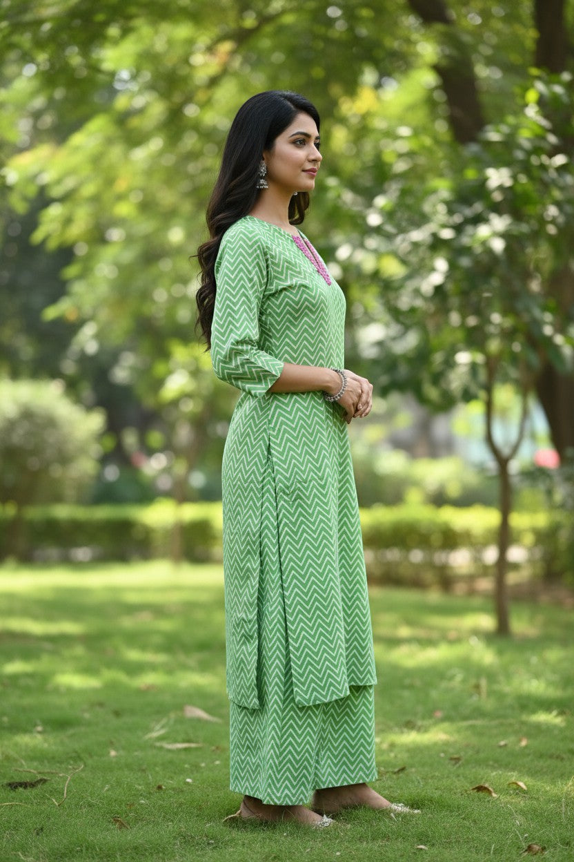 Naanu green chevron print straight kurta with pink embroidered V-neck and 3/4 sleeves, paired with matching pants.
