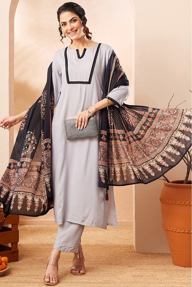 Naanu grey rayon straight kurta set with black contrast border and printed dupatta. Model wears 3/4 sleeves and straight-leg pants.