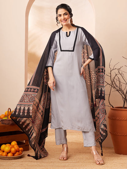 Naanu grey rayon straight kurta set with black contrast border and printed dupatta. Model is wearing 3/4 sleeves and straight pants.