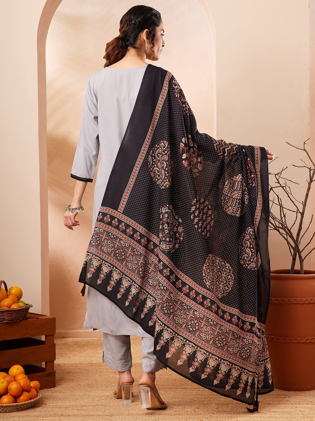Naanu grey rayon straight kurta set with black contrast border and printed dupatta. Model from behind.