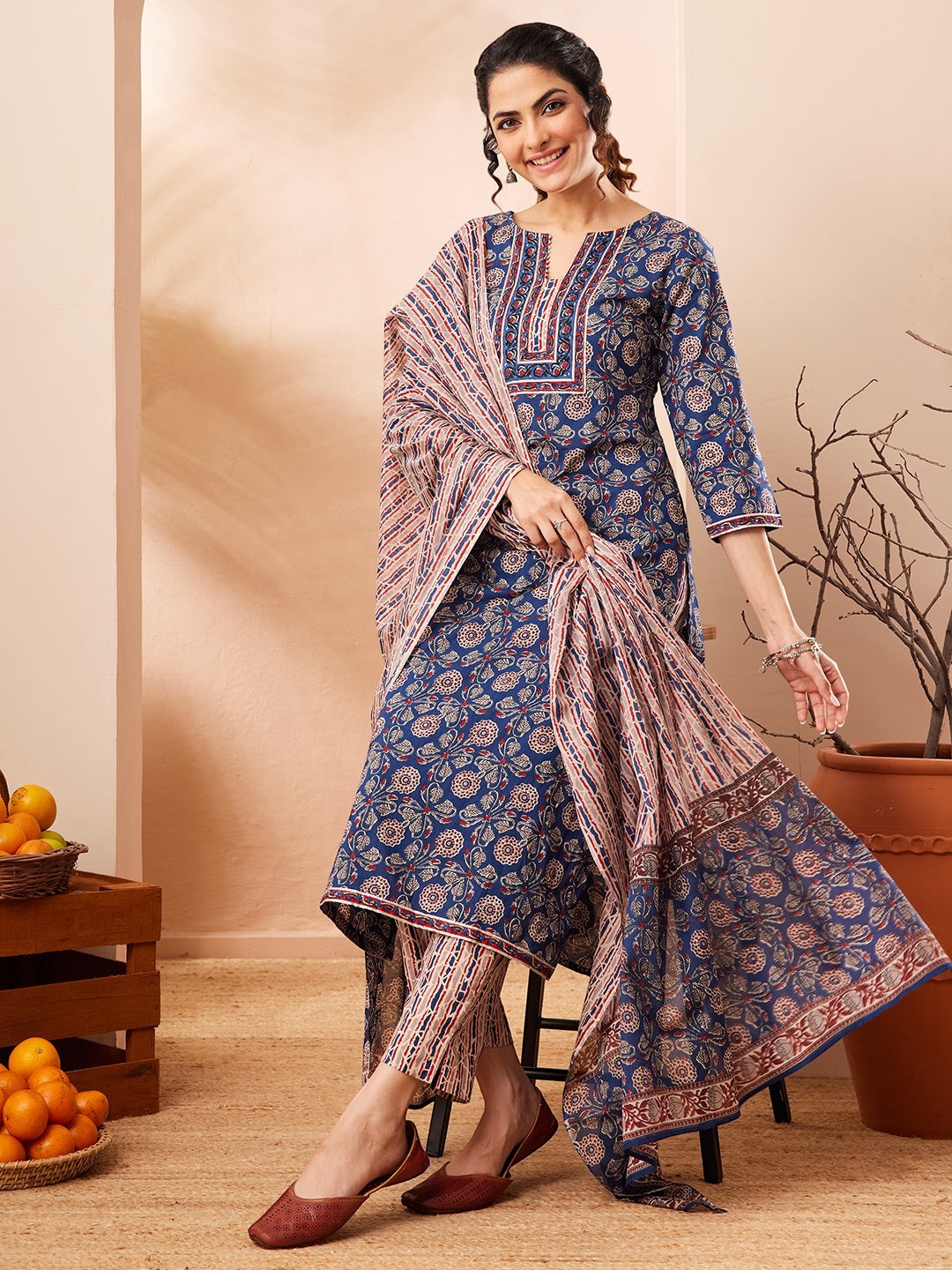 Naanu Indigo Blue Ajrakh block print cotton kurta, pants, and dupatta set with floral motifs and striped accents.