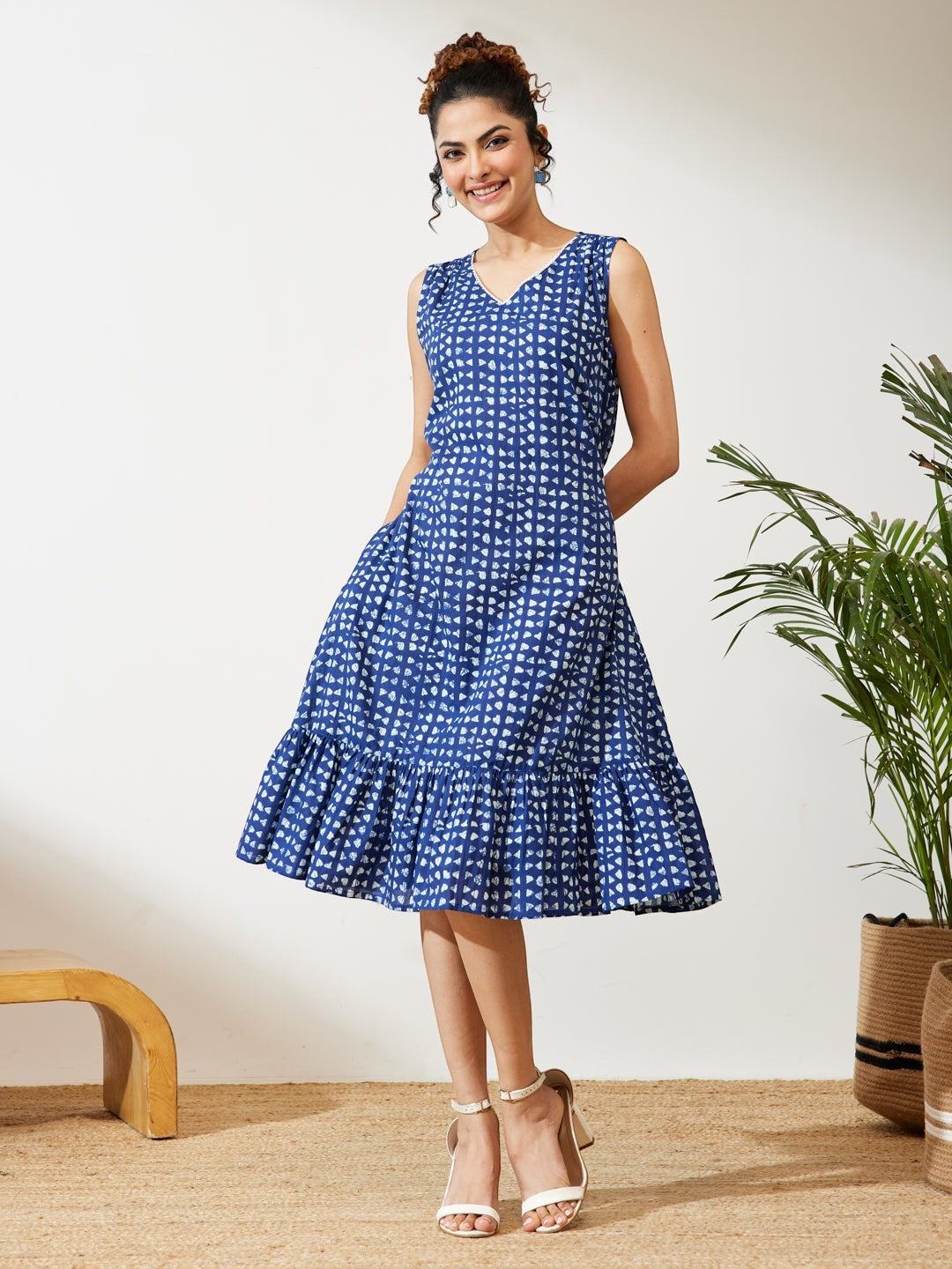 Naanu indigo blue block print sleeveless midi dress with V-neck and tiered ruffled hem.