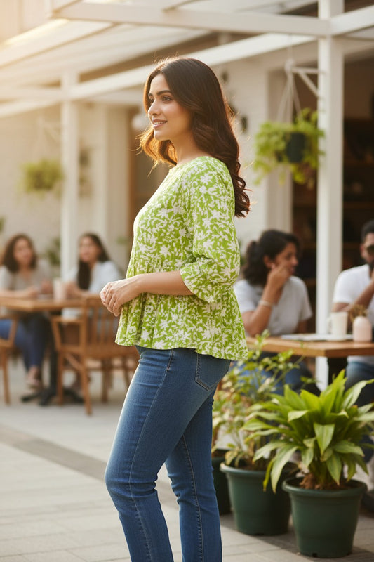 Naanu lime green and white floral print 3/4 sleeve peplum top made of 100% cotton, featuring a boat neckline and ruffle cuffs.