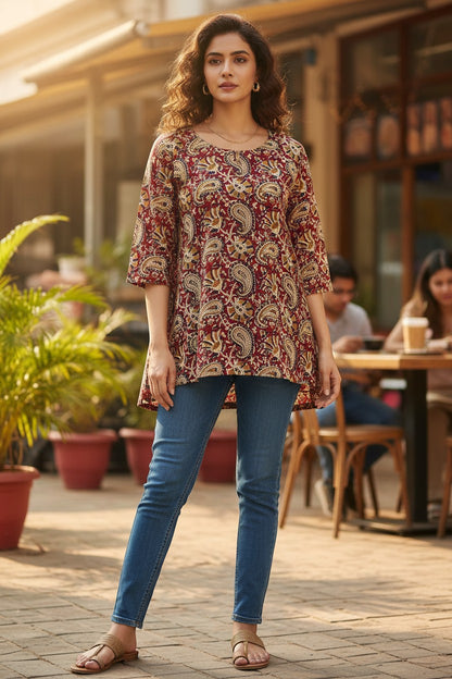 Naanu maroon red cotton short top with cream gold paisley and peacock kalamkari print, round neck, 3/4 sleeves, and asymmetric hem.