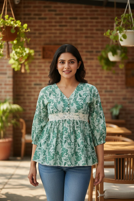 Naanu mint green cotton peplum top with teal botanical print, V-neck, bishop sleeves, and white lace trim.