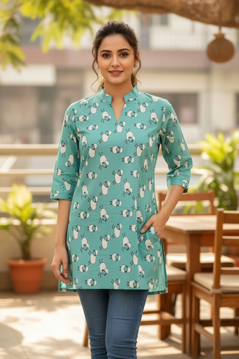 Naanu mint teal short cotton kurti with V-notch neckline and 3/4 sleeves, featuring a playful white sheep print. Straight fit, above knee length.