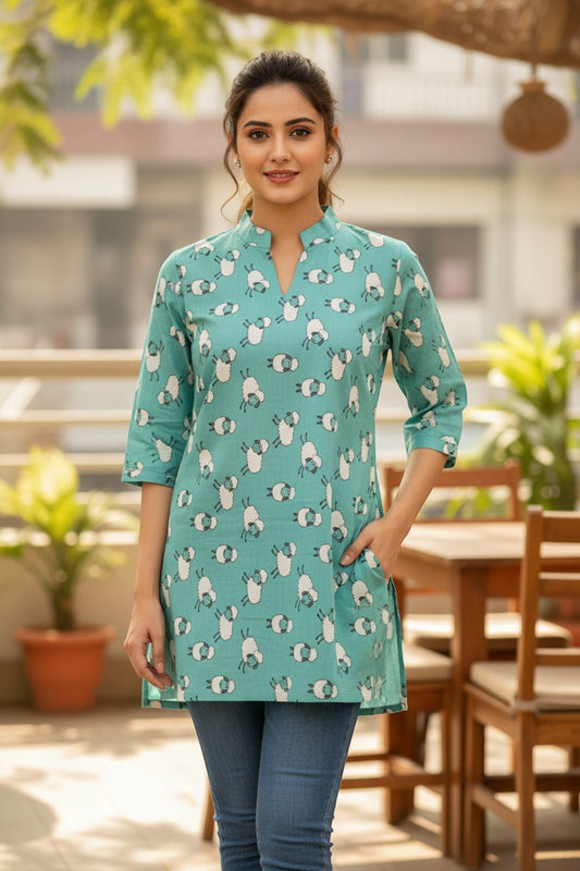 Naanu mint teal short cotton kurti with V-notch neckline and 3/4 sleeves, featuring a playful white sheep print. Straight fit, above knee length.