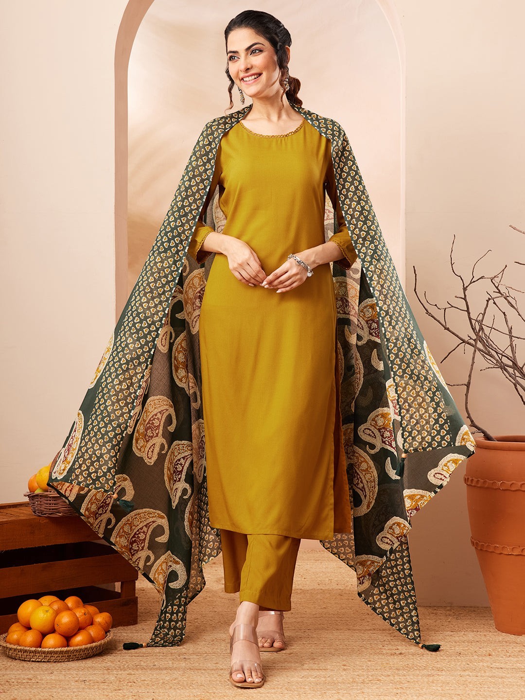 Naanu mustard yellow solid straight kurta with gold trim, palazzo pants, and a forest green paisley dupatta.