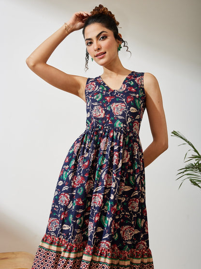 Naanu navy cotton midi dress with V-neck, empire waist, and tiered border hem featuring a Kalamkari floral print in red, green, and ivory.