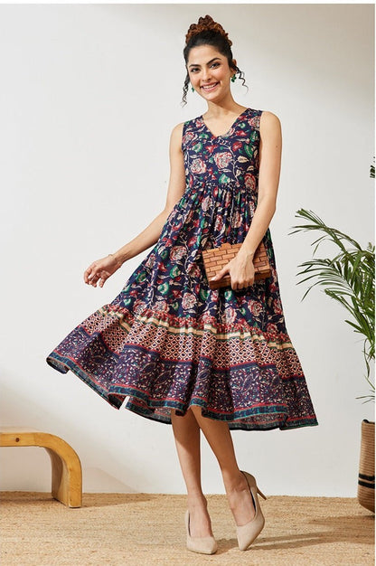 Naanu navy cotton midi dress with V-neck, empire waist, and tiered floral border hem. Sleeveless design with deep side pockets.